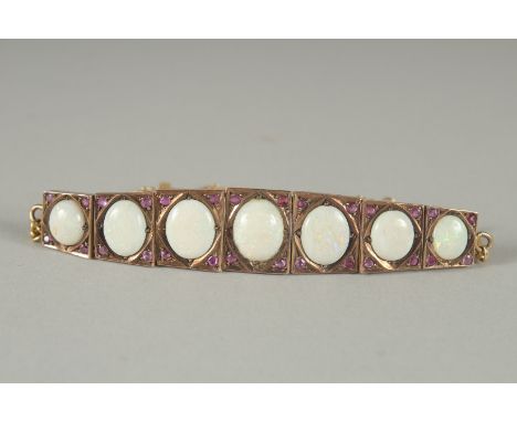 A GOOD GOLD AND SEVEN STONE OPAL BRACELET.