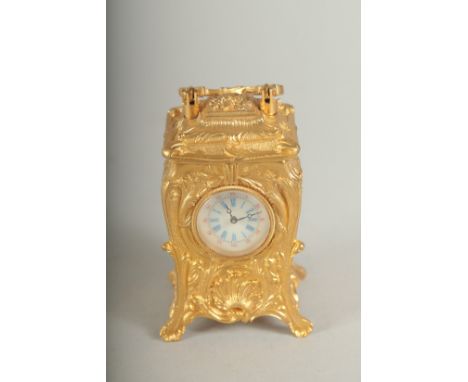 A SMALL GILDED CARRIAGE CLOCK with blue and white Roman numerals and carrying handles.  7cm high.