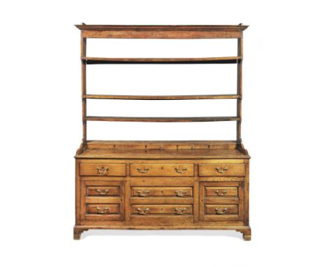 A George III joined oak high dresser, circa 1760The open rack with three stepped shelves, above a shallow box-base of five fa