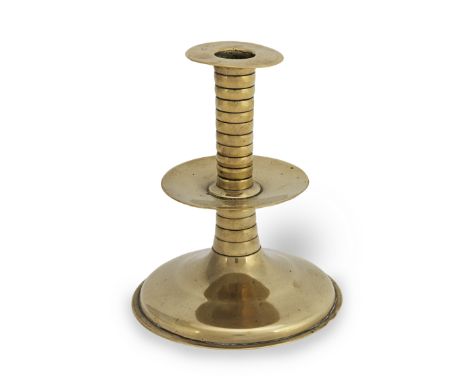 A rare mid-17th century brass trumpet-based socket candlestick, English, circa 1650-70The broad socket flange stamped with th