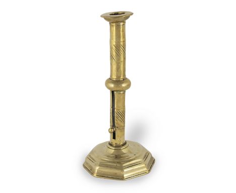 An early 18th century brass ejector socket candlestick, English/French, circa 1720With broad flange, the stem with central bu