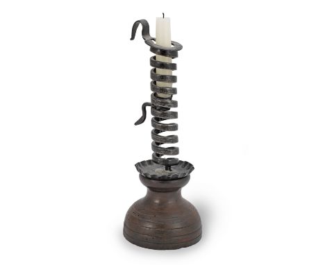 A 19th century wrought iron spiral candlestick on a painted beech base, FrenchThe spiral terminating in a hook, and fitted wi