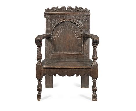 A rare and interesting Elizabeth I joined oak 'caqueteuse' open armchair, circa 1580The broad back-panel with a nulled-carved