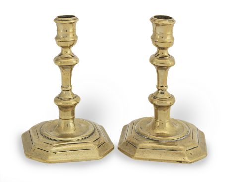 A pair of George I brass socket candlesticks, circa 1720Each with waisted vase-shaped socket with moulded rim, and seamed ste