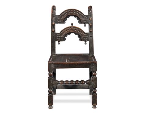 A Charles II joined oak backstool, Derbyshire, circa 1670Having a pair of arched splats, each  profusely chip-carved, with a 