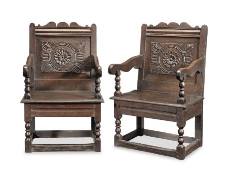 A rare pair of Charles II joined oak panel-back open armchairs, Cheshire, circa 1680Each having a relief-carved back panel, d