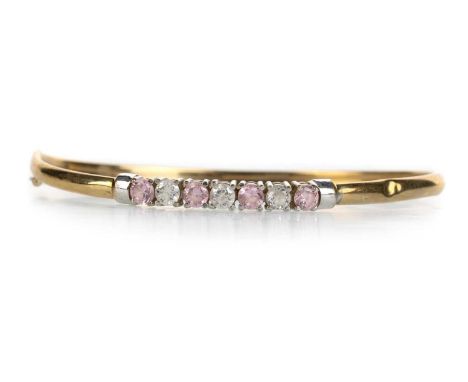 GEM SET BANGLE, NINE CARAT GOLD set with a row of round pink and white stonesQty: 4.67g