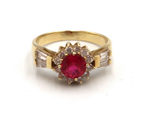 A ruby (possibly synthetic) and brilliant cut diamond cluster ring with tapered baguette diamonds to each shoulders. Size Q. 