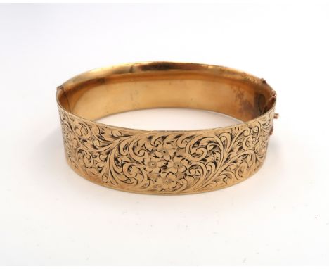 A 9ct gold and solid metal core, Victorian style bangle, hinged with two panels, one foliate engraved, total weight 51.1g, in