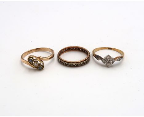 Three gold rings - An 18ct gold panel ring set with six diamonds size N - a 9ct gold (tested) three stone ring size P and a 9