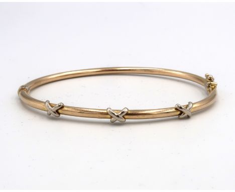A bi colour hinged bangle with cross detail. Stamped 3475. Weight 4.25 grams