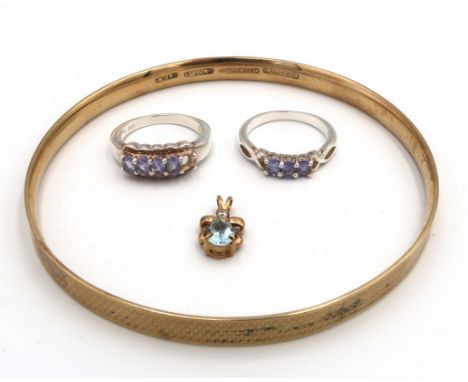 Two tanzanite rings. Size P1/2. Stamped 925. one stone missing. Weight 6.53 grams. A slave bangle stamped 9ct with bronze cor