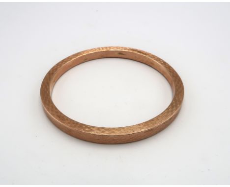 A 9ct rose gold bangle of circular form with engine turned decoration, 73mm diameter, 15.2g.