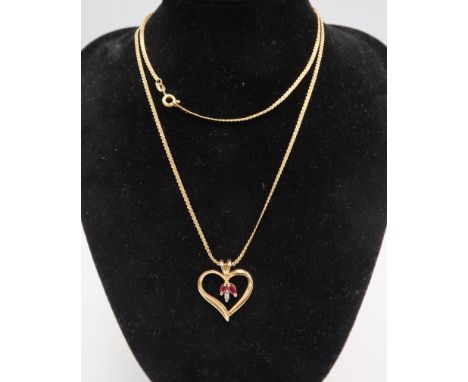 An s link chain stamped 750. Suspending an open heart pendant with ruby and diamond detail. Stamped 10K. Weight 7.03 grams