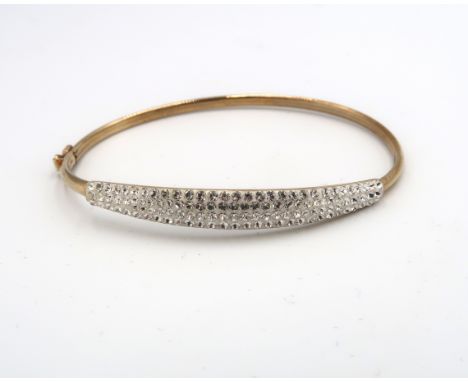 A 9ct gold bangle, set with white stones, 5.87 by 5.17cm internal diameter, 3.4g.