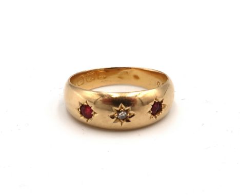 An 18ct gold diamond and red stone gypsy set three stone ring. Size K. Weight 2.01 grams