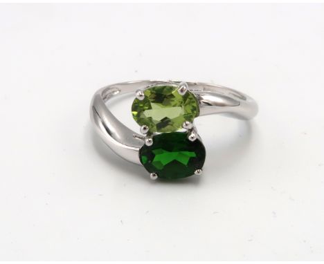 A 9ct white gold and green stone crossover ring, likely peridot and tsavorite, size U, 3.9g.