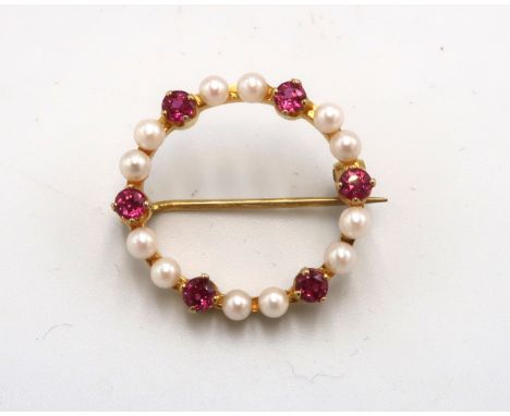 A 9ct gold, seed pearl and ruby circular brooch, set with six rubies, intersperced with a pair of seed pearls, 22.5mm diamete