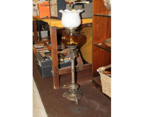 AN EARLY 20TH CENTURY ELKINGTON OIL LAMP WITH AMBER GLASS RESERVOIR ON A PLATED COLUMN BASE AND WHITE SHADE  
