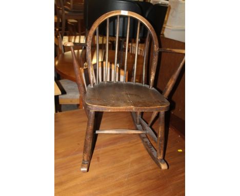 AN ERCOL SPINDLE BACK CHILD'S ROCKING CHAIR 