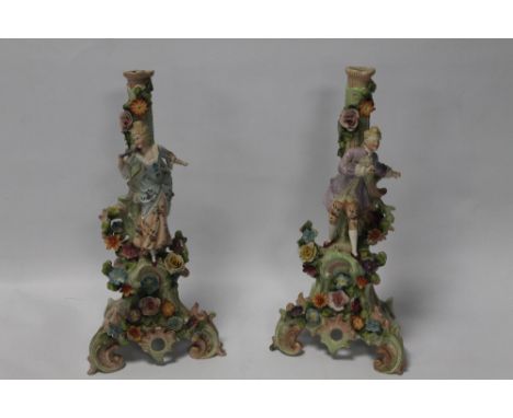 A PAIR OF DRESDEN STYLE STANDS DECORATED WITH A MAN AND WOMEN IN TYPICAL FLORAL DRESS 