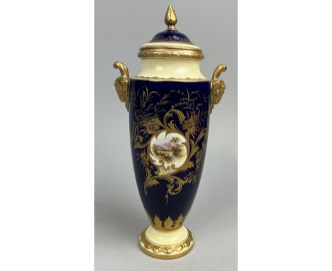 A COALPORT PORCELAIN URN AND COVER WITH CENTRAL PAINTED LANDSCAPE SCENE, GILT RAMS HEAD HANDLES AND DETAILING ON BLUE GROUND2