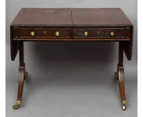 A 19th century mahogany sofa table
The twin flap top above two frieze drawers with opposing dummy drawers, standing on end tr