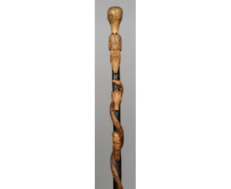 A Folk Art carved wooden walking stick
Decorated with a serpent, figural busts and animals heads.  91 cm long.   CONDITION RE