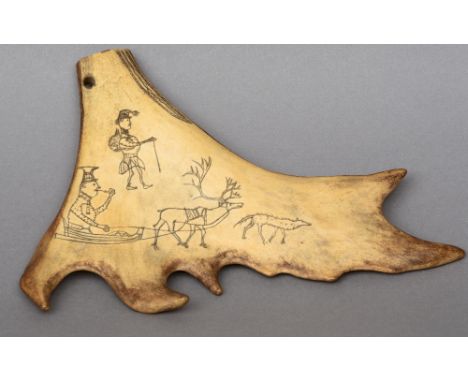 A small piece of scrimshawed elk or caribou antler
Decorated with an elk towing a sled, figures and a wolf, the reverse with 