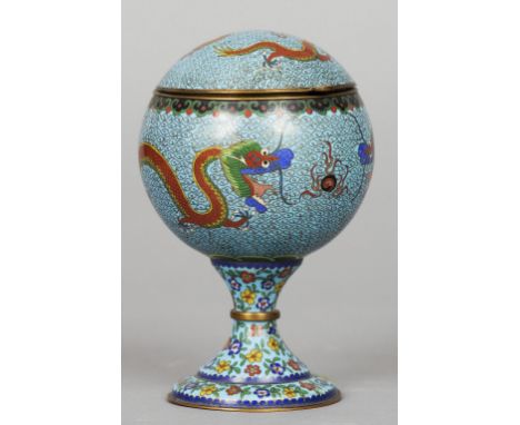 A Chinese cloisonne tea caddy
Of globular form, decorated with five clawed dragons chasing a flaming pearl and with lidded in