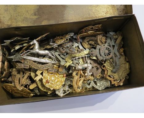 A collection of military hat badges contained in a Cameron Highlanders trinket box 