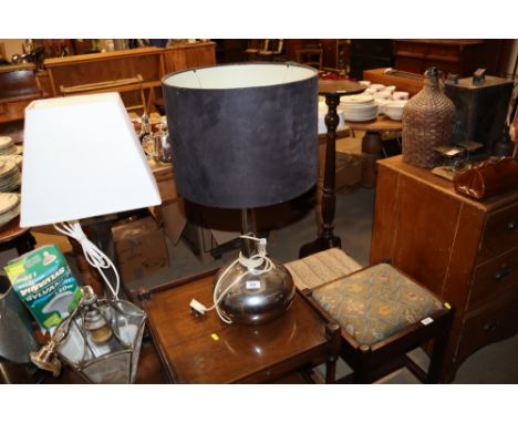 A table lamp and silvered base and dark shade