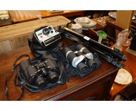 A camera tripod; two pairs of binoculars; and a Polaroid land camera 