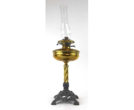 A 19th century oil lamp, the brass resevoir on a spiral column over a cast metal base of Art Nouveau form, h. 41 cm CONDITION