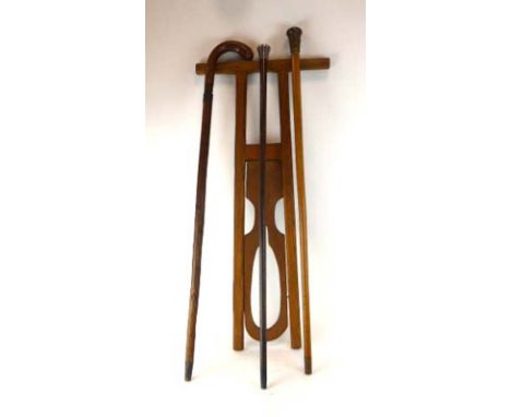 A walking cane, the brass finished pommel of Oriental design and unscrewing to reveal a glass phial/tube, together with a 19t