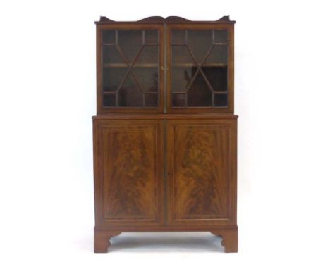 A 19th century mahogany and strung cabinet of small proportions, the two glazed doors over two solid doors on bracket feet, w