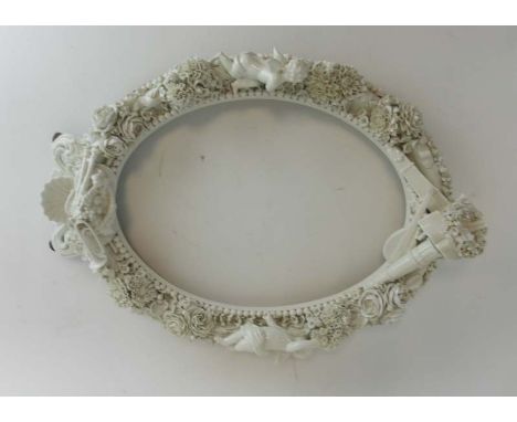 A Meissen-style blanc de chine photograph/mirror frame of oval form profusely decorated with musical instruments, putti and f