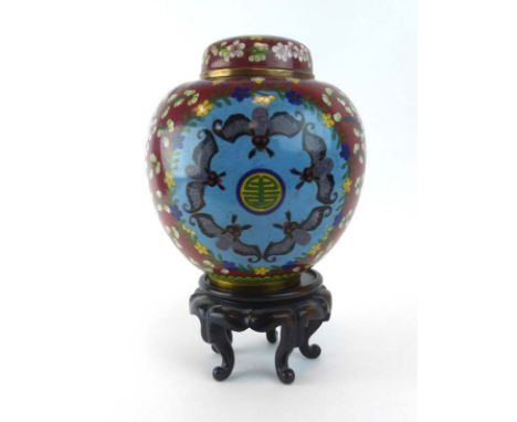 A cloisonne ginger jar and cover decorated with bats within a foliate ochre ground on a carved stand, overall h. 30.5 cm COND