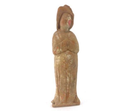 A Tang Dynasty painted pottery figure modelled as a lady wearing a long dress and holding her hands clasped, h. 37 cm*see Lot