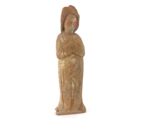 A Tang Dynasty painted pottery figure modelled as a lady wearing a long dress and holding her hands clasped, h. 37 cm*see Lot