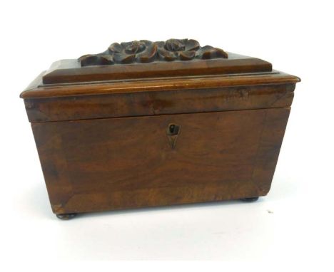 A 19th century walnut and crossbanded tea caddy of sarcophagus form with a foliate carved top, on bun feet, 15 cm CONDITION R