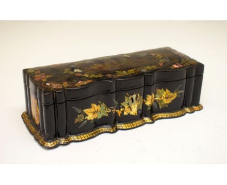 Victorian lacquered papier-mâché table box of serpentine form, the hinged cover decorated with castle ruins, 25cm wide  