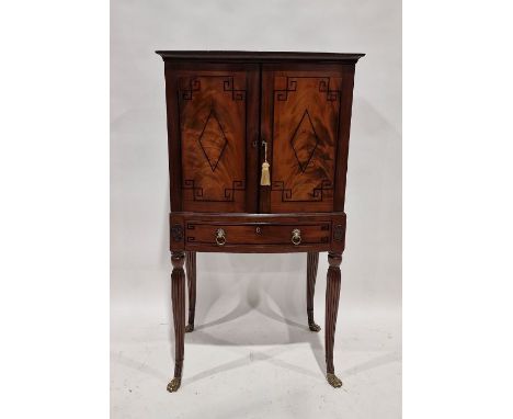 Empire-style bowfronted cabinet on stand, having single shelf enclosed by pair panelled doors with ebonised lozenge and geome