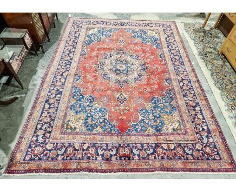 North West Persian Birjand red ground carpet with central floral medallion enclosed by floral pattern to multiple herati bord