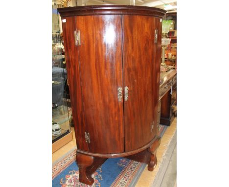 A 19th Century mahogany free standing corner cupboard, of bow fronted form, the doors opening to reveal four fitted shelves a