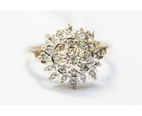 A 9ct yellow gold diamond cluster ring, illusion set in the style of a flower, head size approx 12mm, size M½, with a total g