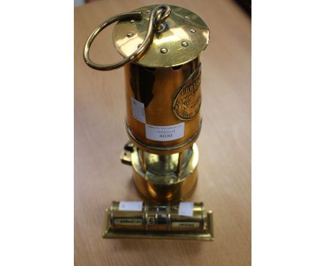 A brass miners lamp 'The Protector' together with a brass perpetual calendar marked Victor Blagden & Co (2)