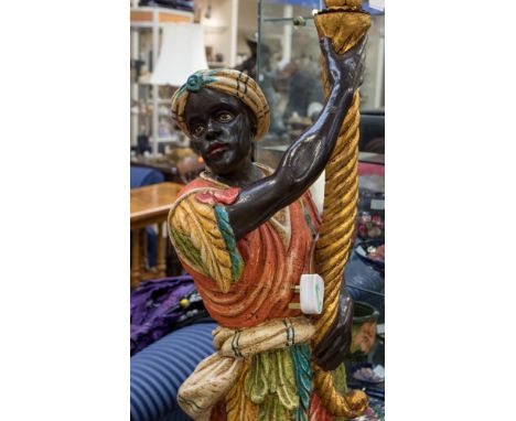 A pair of early 20th Century Blackamoors. Both holding candelabra, converted to modern electricity.