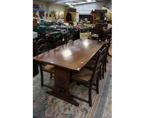 A traditional dining room suite, comprising a solid oak dining table with a trestle type base, together with a set of six lad