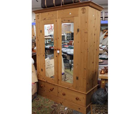 A contemporary pine double wardrobe, fitted with two mirror inset doors, fitted with a single drawer to base
